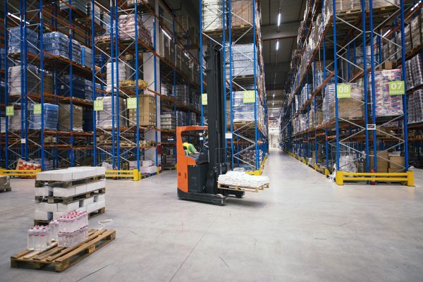 Industrial building large warehouse interior with forklift and palette with goods and shelves.